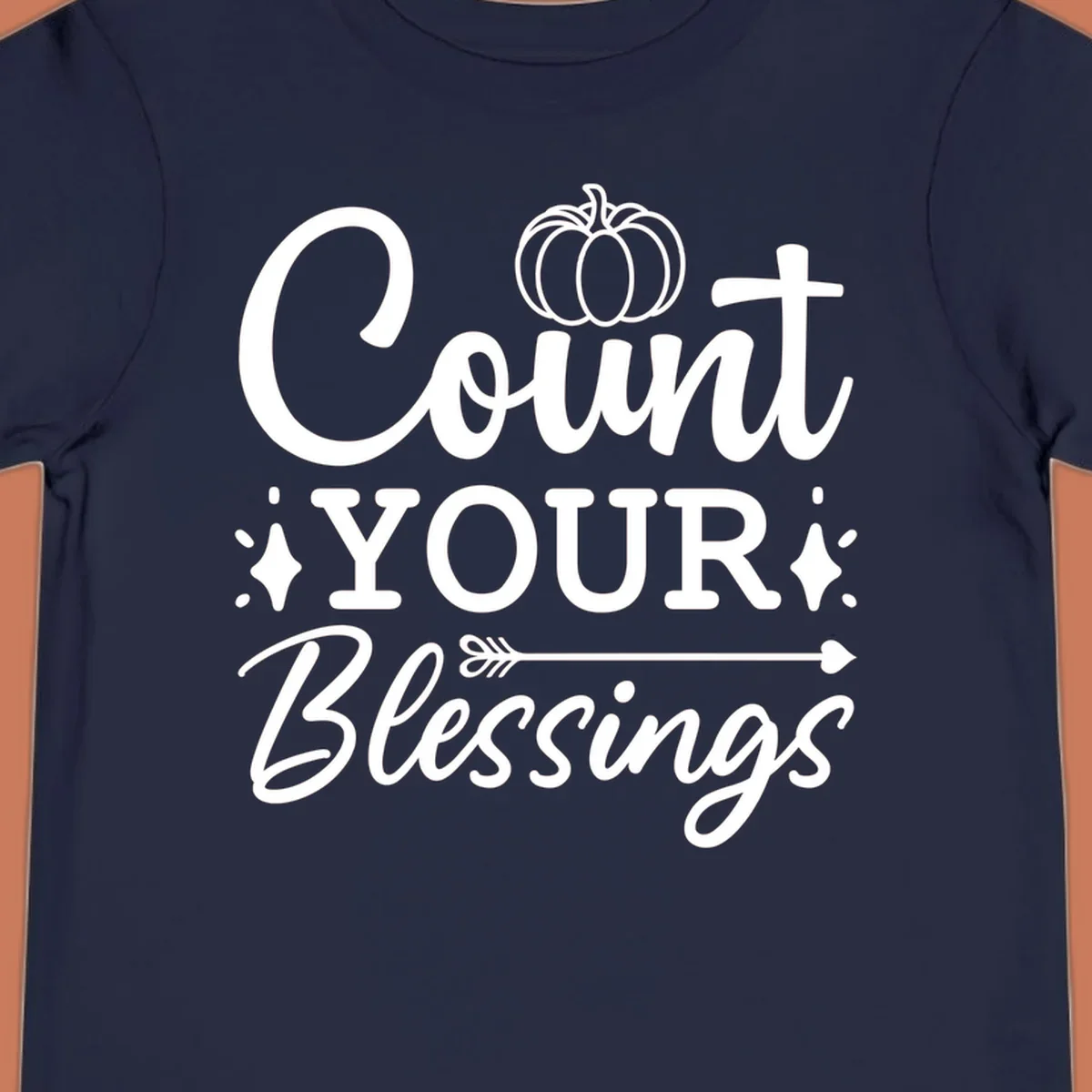 Count your blessings text with pumpkin and arrow graphic, in white.