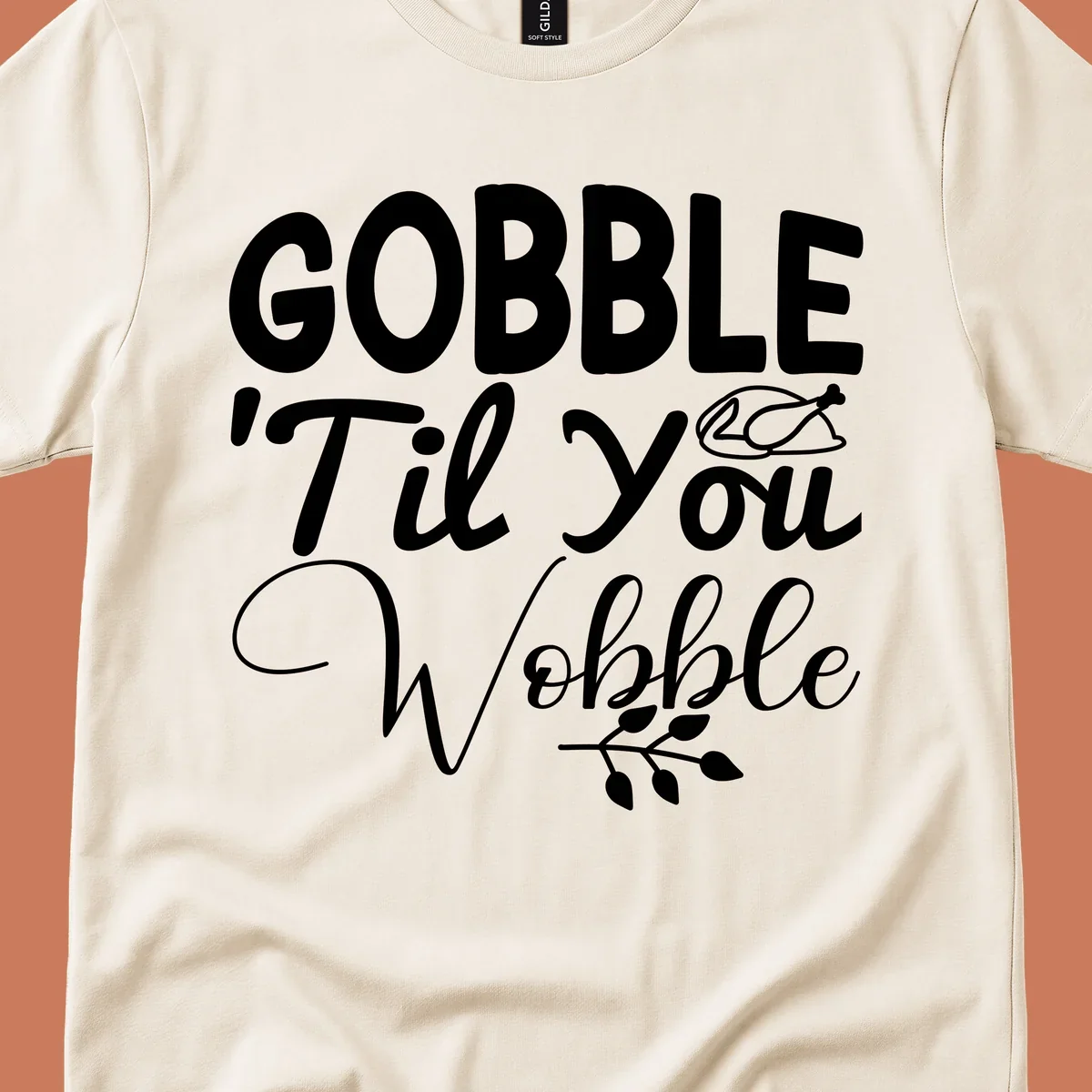 Gobble wobble thanksgiving phrase with roasted turkey illustration and leafy branch.