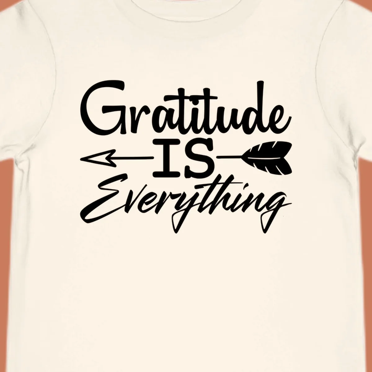 Gratitude Is Everything typography design with an arrow and feather graphic.