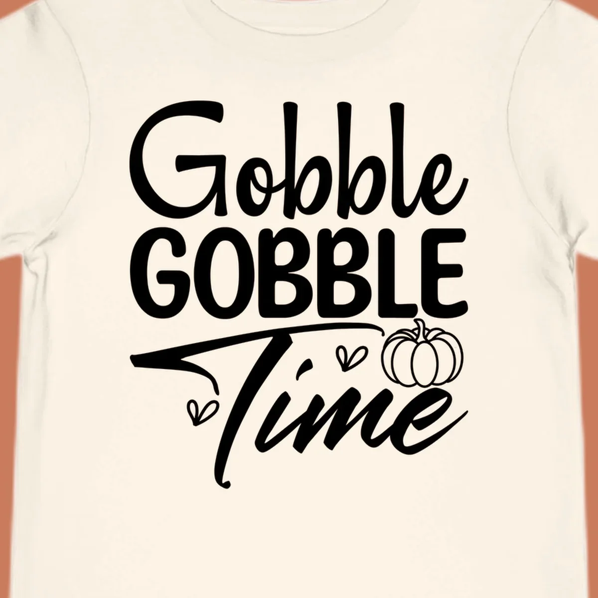 Gobble Gobble Time phrase with pumpkin and hearts, white typography on black background.