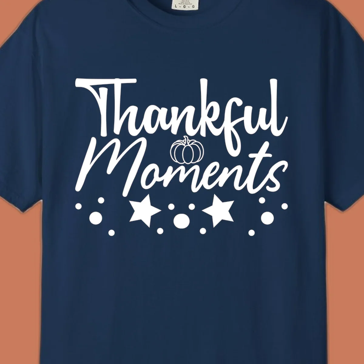 Thankful Moments autumn script text with pumpkin, stars, and dots graphic.