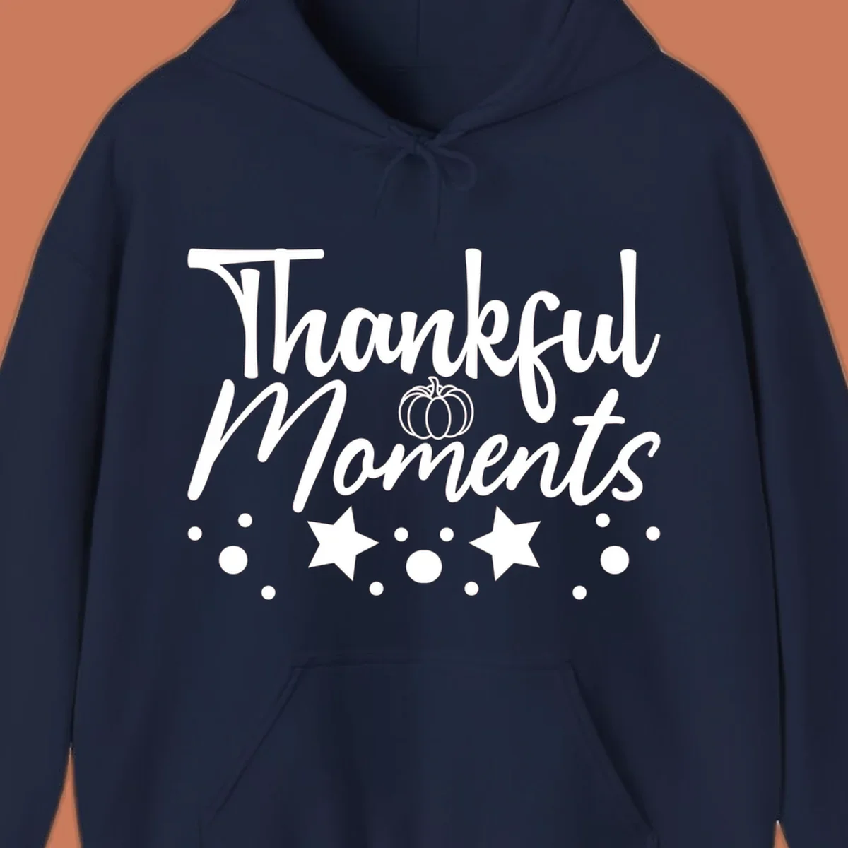 Thankful Moments autumn script text with pumpkin, stars, and dots graphic.