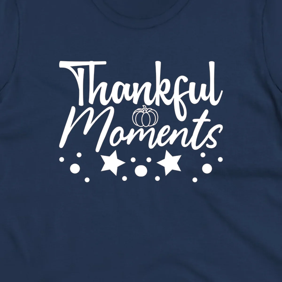 Thankful Moments autumn script text with pumpkin, stars, and dots graphic.