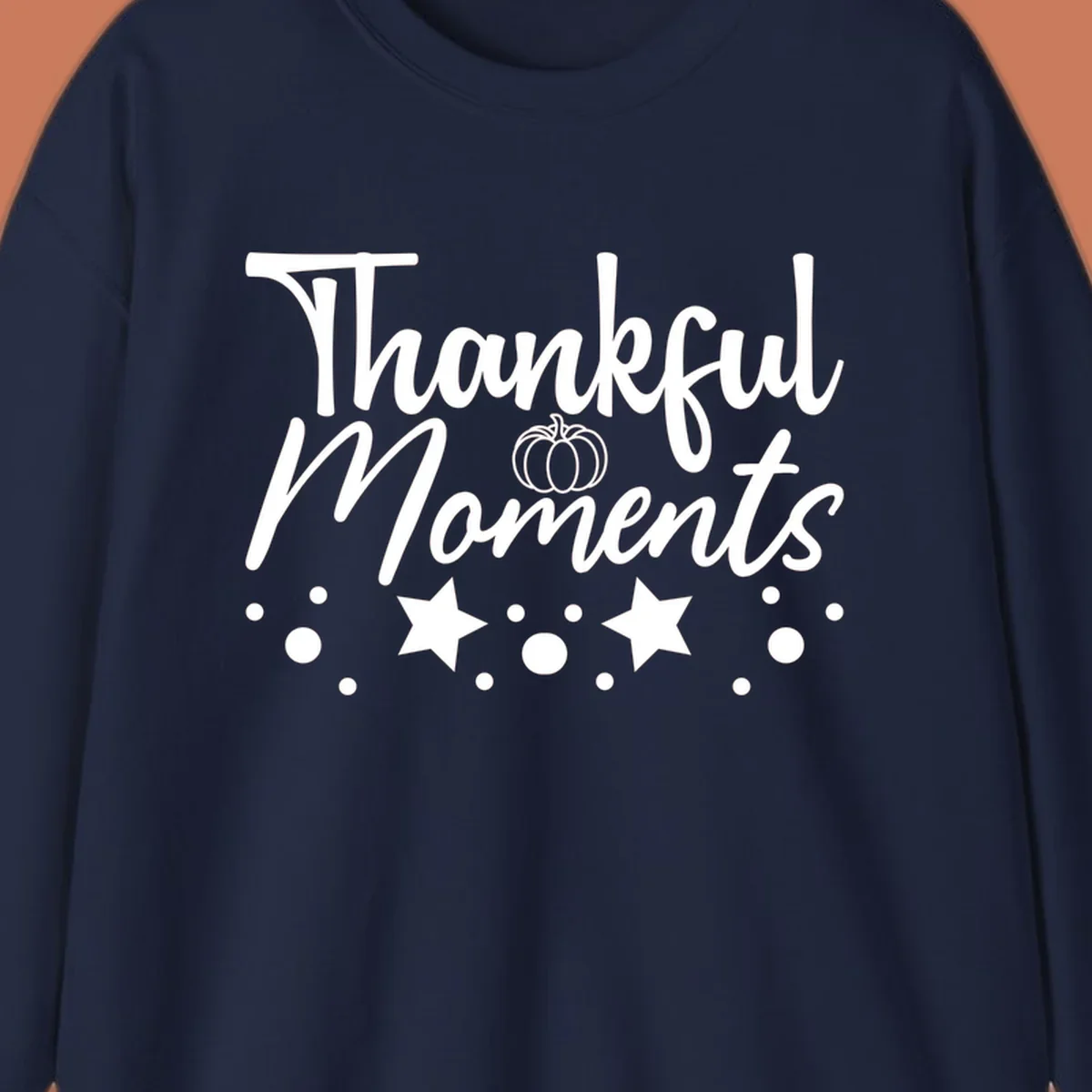 Thankful Moments autumn script text with pumpkin, stars, and dots graphic.