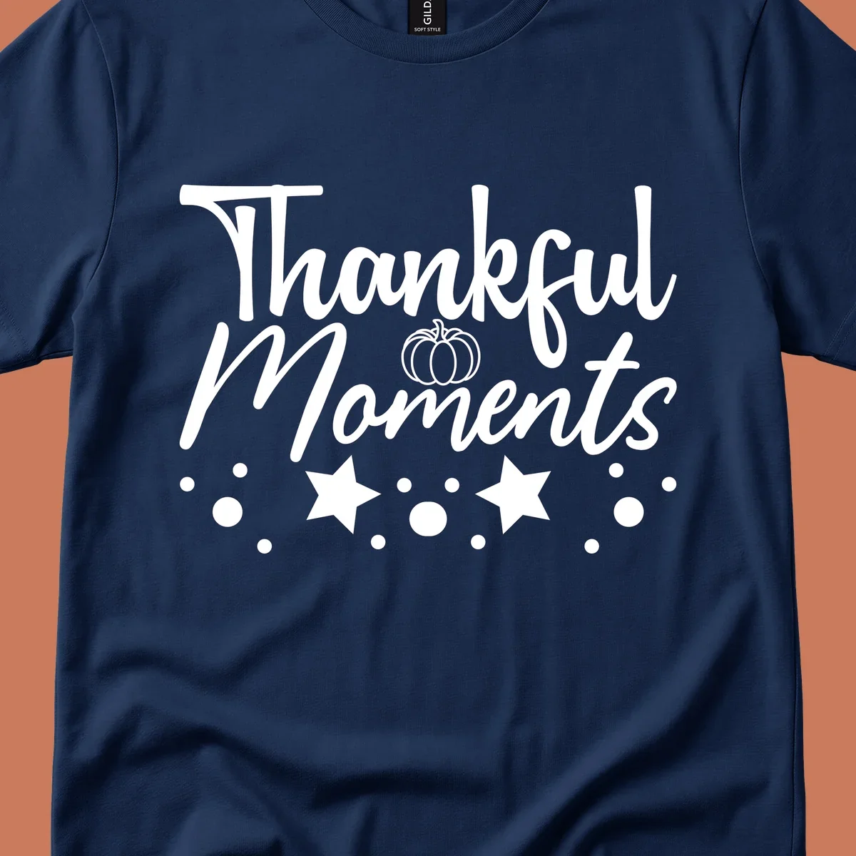 Thankful Moments autumn script text with pumpkin, stars, and dots graphic.