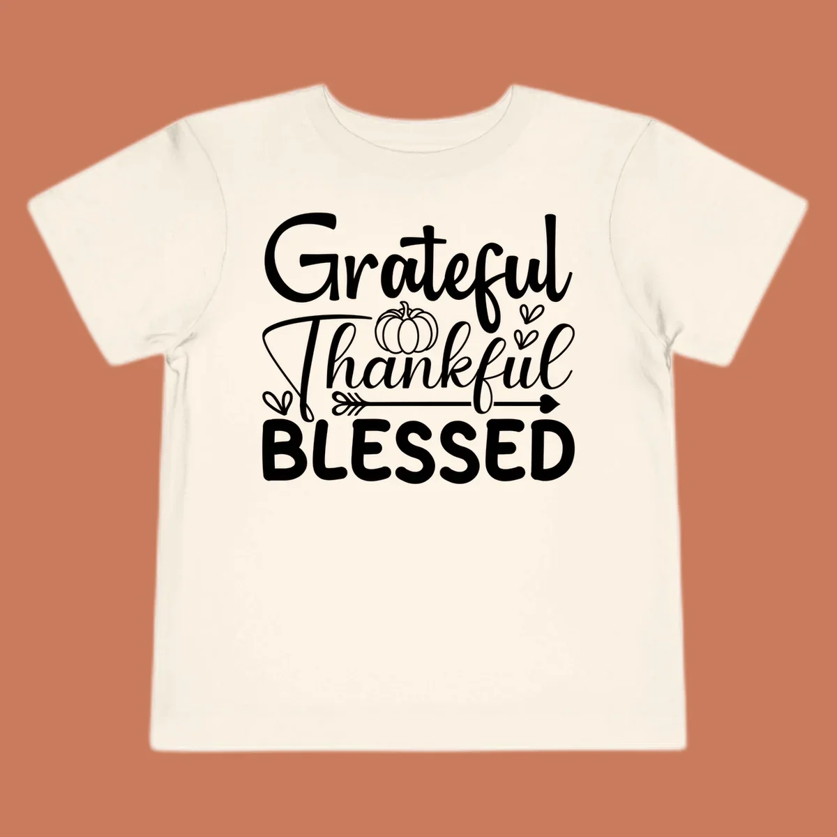 Grateful Thankful Blessed typography design with pumpkin, hearts, and arrow.