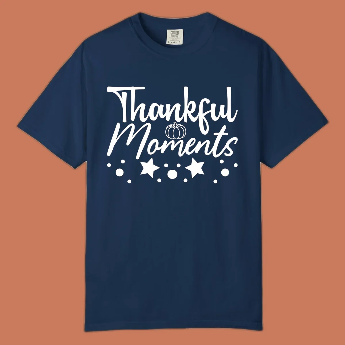 Thankful Moments autumn script text with pumpkin, stars, and dots graphic.