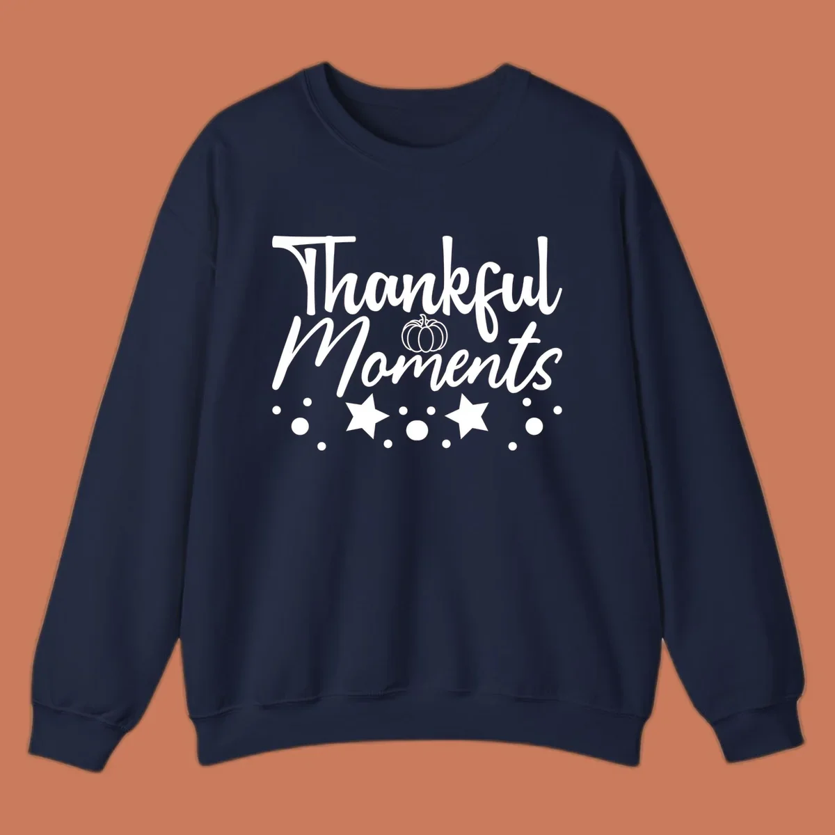Thankful Moments autumn script text with pumpkin, stars, and dots graphic.