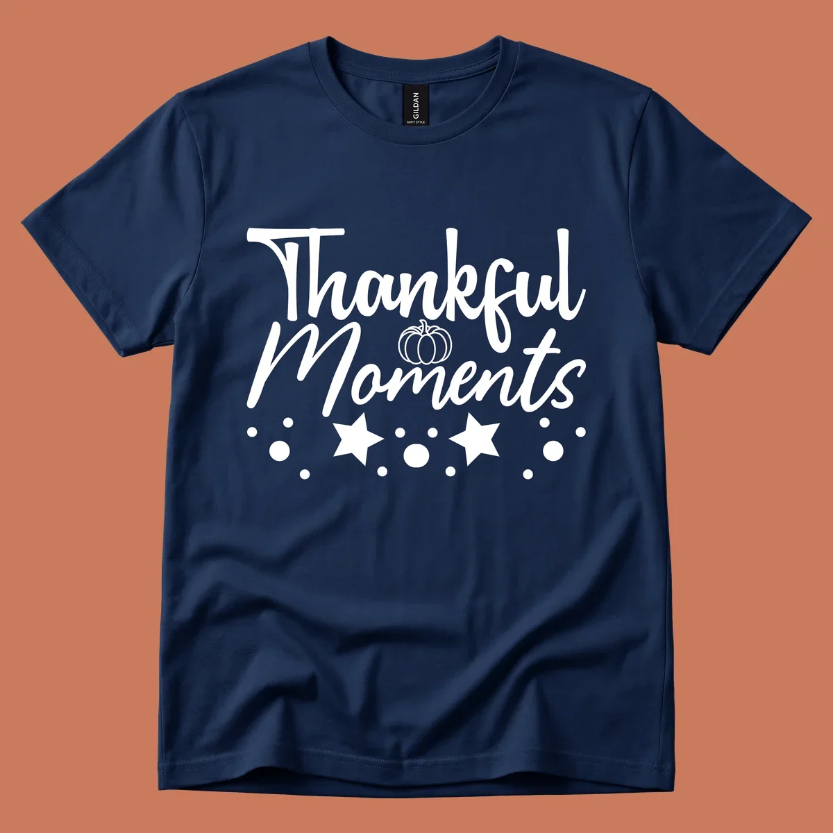 Thankful Moments autumn script text with pumpkin, stars, and dots graphic.