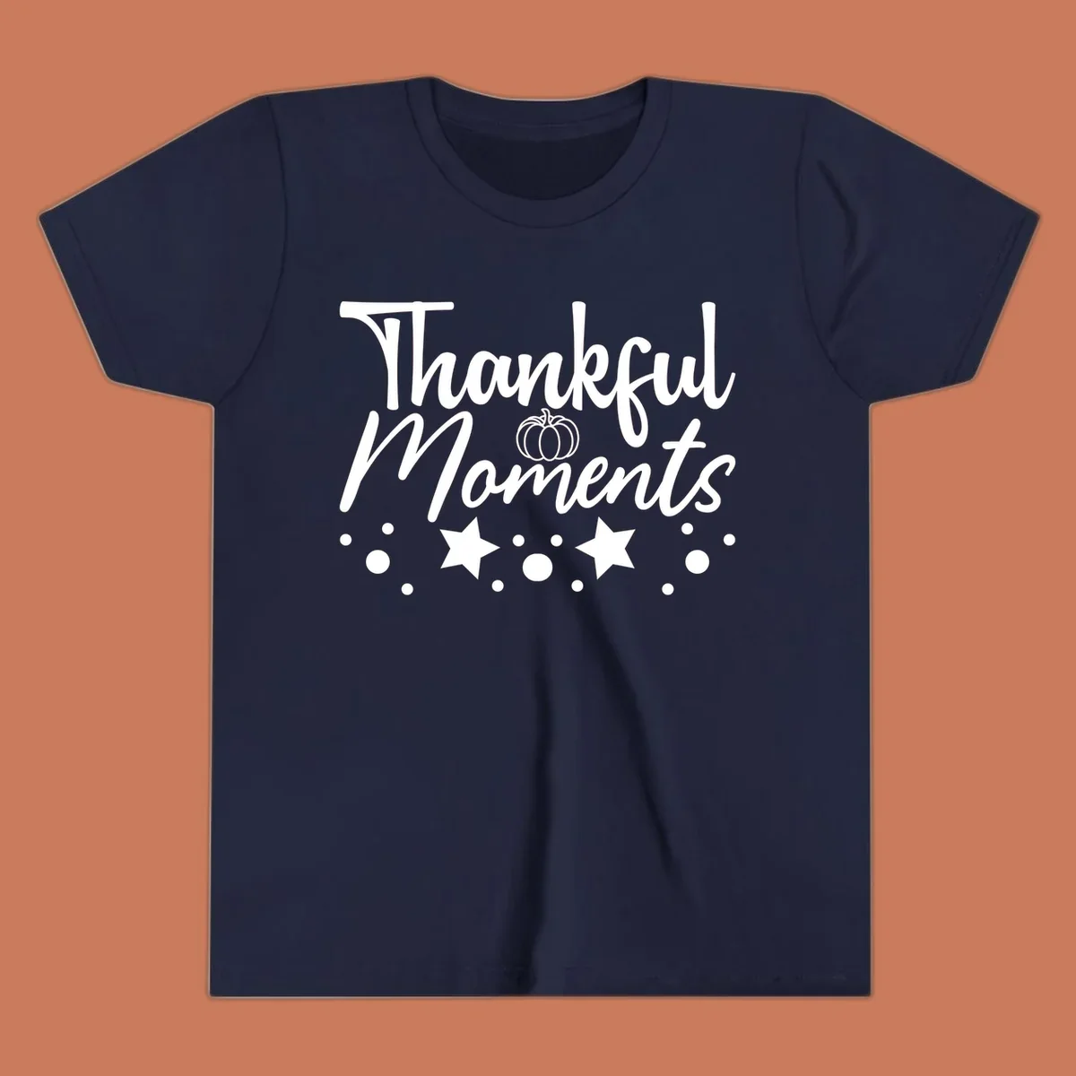 Thankful Moments autumn script text with pumpkin, stars, and dots graphic.