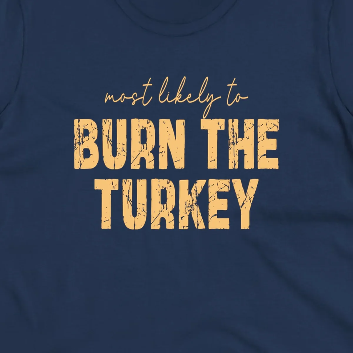 Most likely to burn the turkey text design in distressed orange and tan.