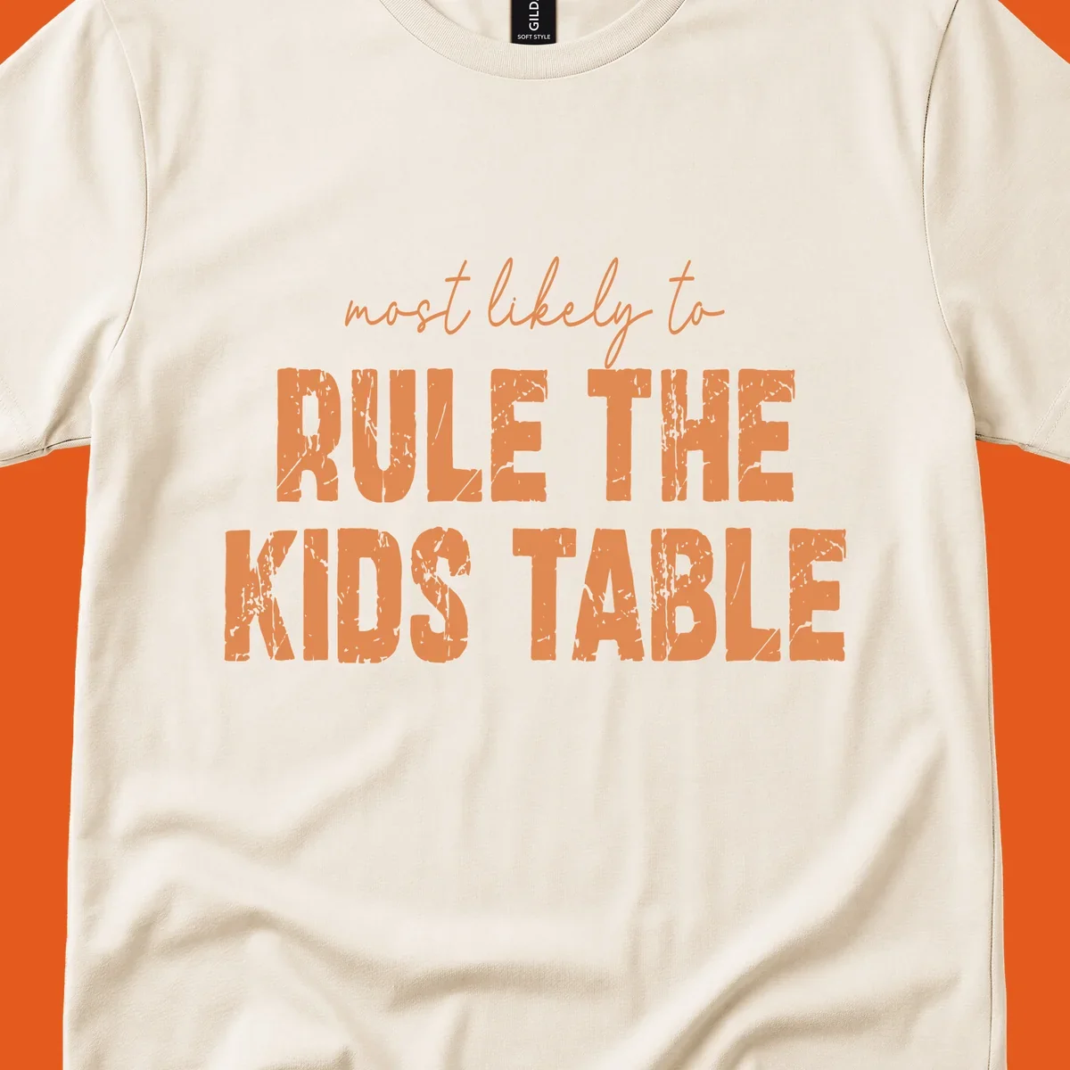 Text design 'most likely to rule the kids table' in distressed orange font.