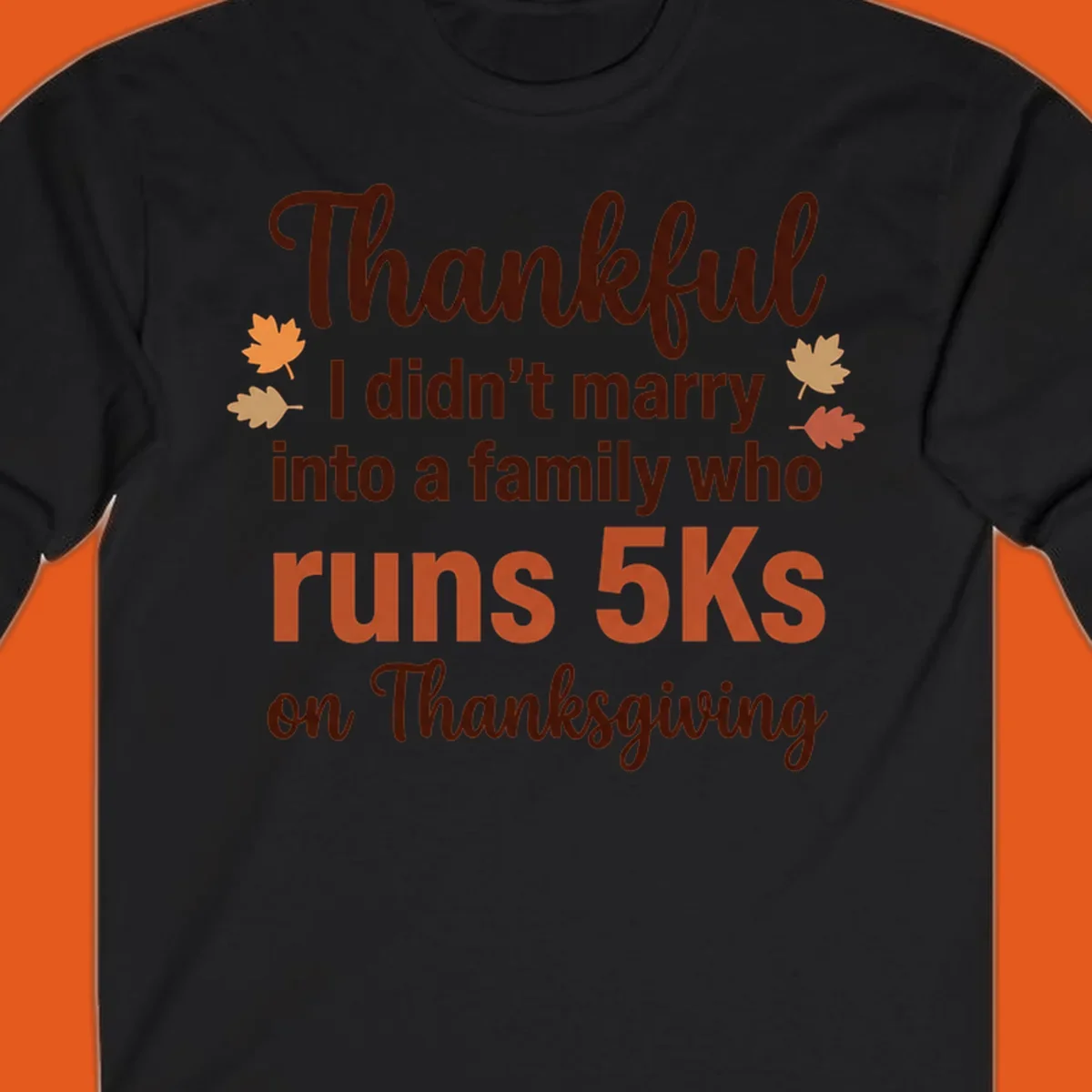 Text design 'Thankful I didn't marry into a family who runs 5Ks on Thanksgiving' with autumn leaves, for Thanksgiving 5k runner.