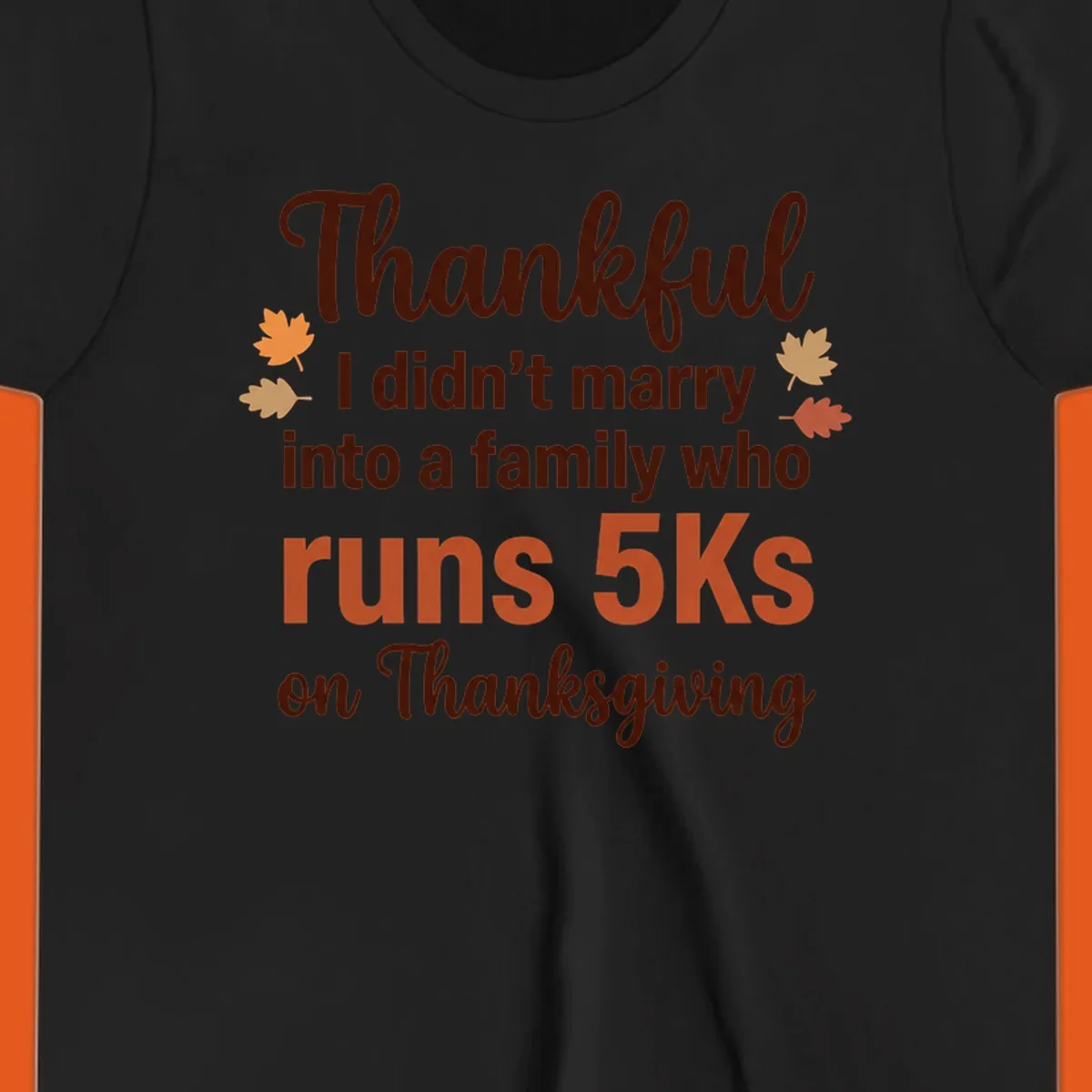 Text design 'Thankful I didn't marry into a family who runs 5Ks on Thanksgiving' with autumn leaves, for Thanksgiving 5k runner.