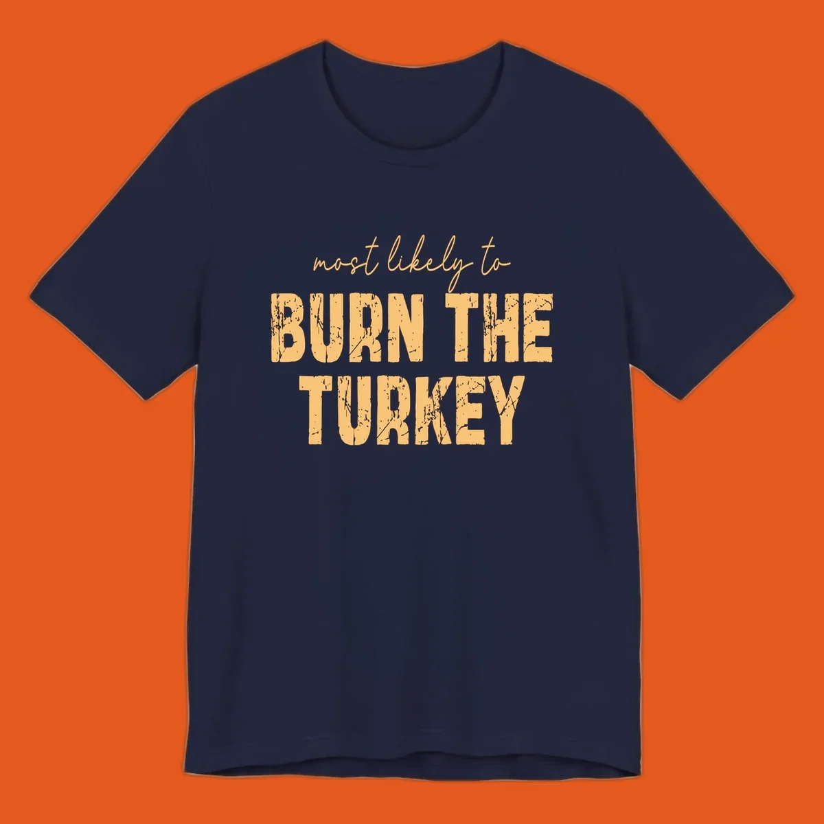 Most likely to burn the turkey text design in distressed orange and tan.