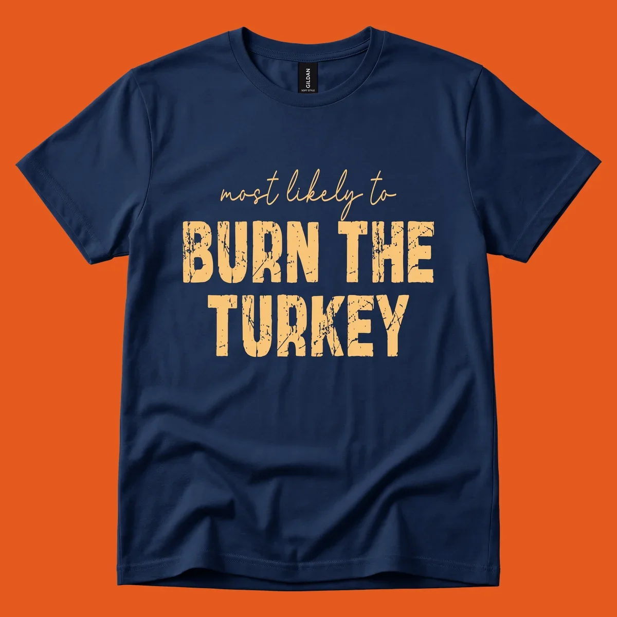 Most likely to burn the turkey text design in distressed orange and tan.