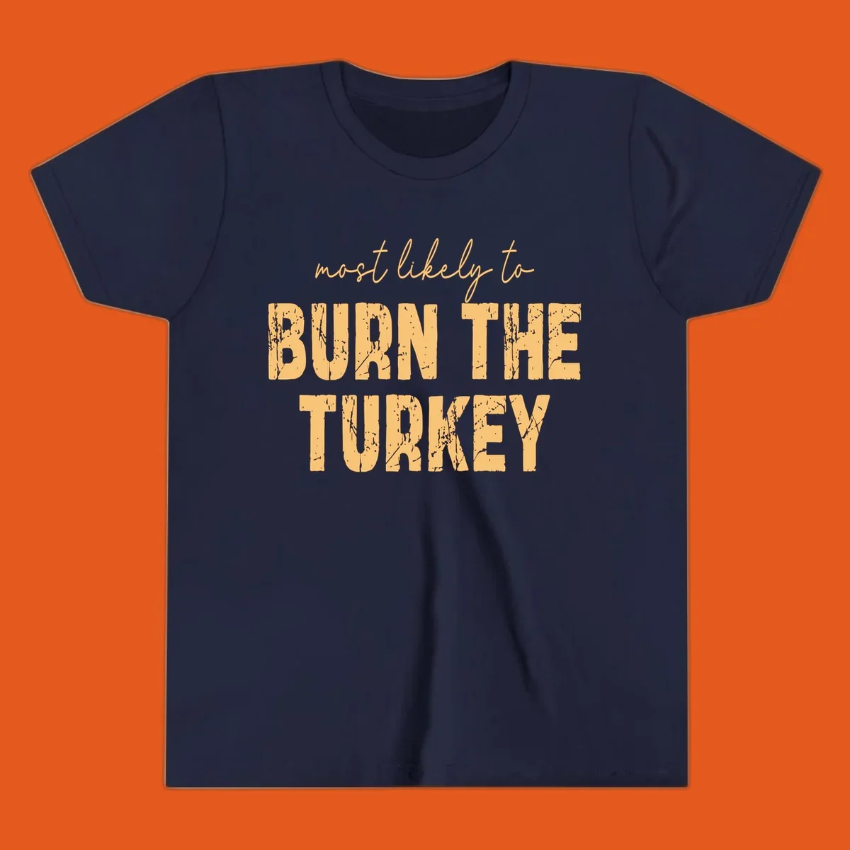 Most likely to burn the turkey text design in distressed orange and tan.