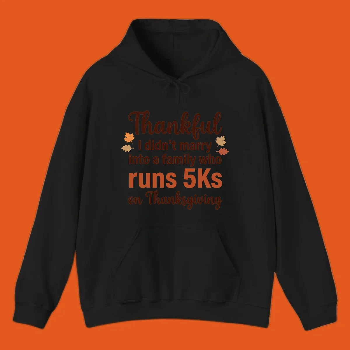 Text design 'Thankful I didn't marry into a family who runs 5Ks on Thanksgiving' with autumn leaves, for Thanksgiving 5k runner.