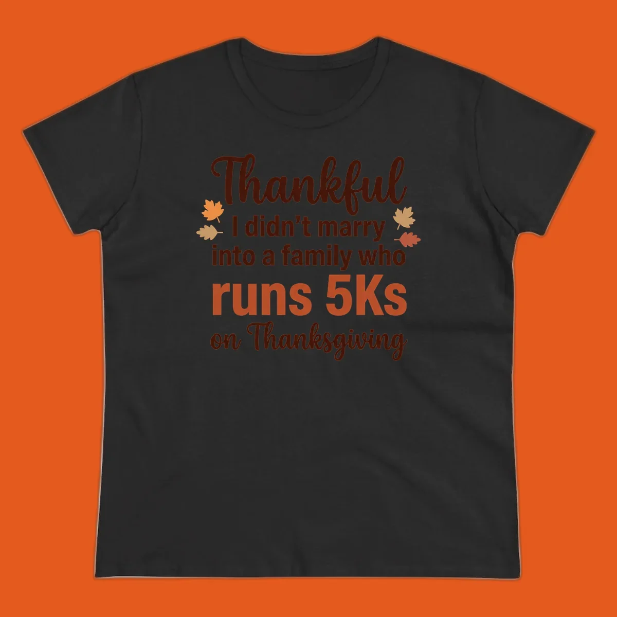 Text design 'Thankful I didn't marry into a family who runs 5Ks on Thanksgiving' with autumn leaves, for Thanksgiving 5k runner.