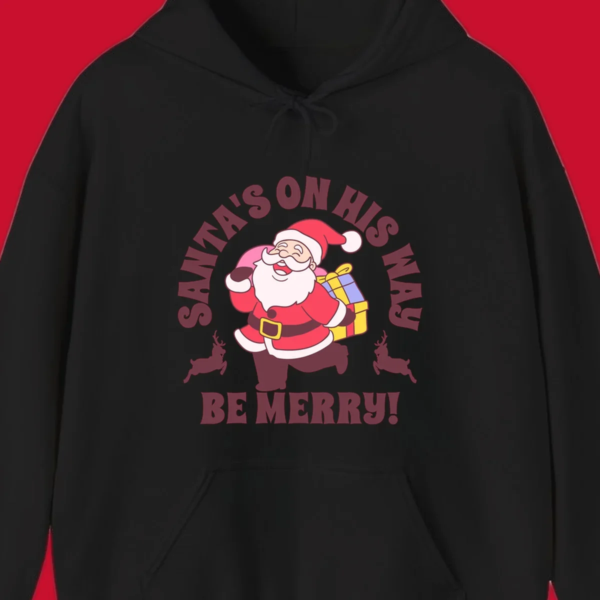 Illustration of Santa Claus running with gifts and reindeer, text reads Santa's on His Way Be Merry.