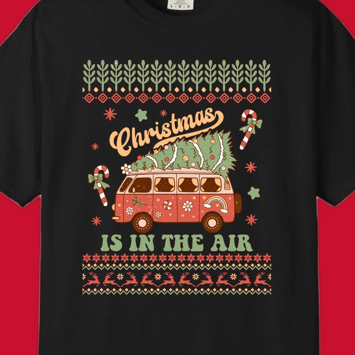Retro Christmas van with tree on roof and 'Christmas IS IN THE AIR' text.
