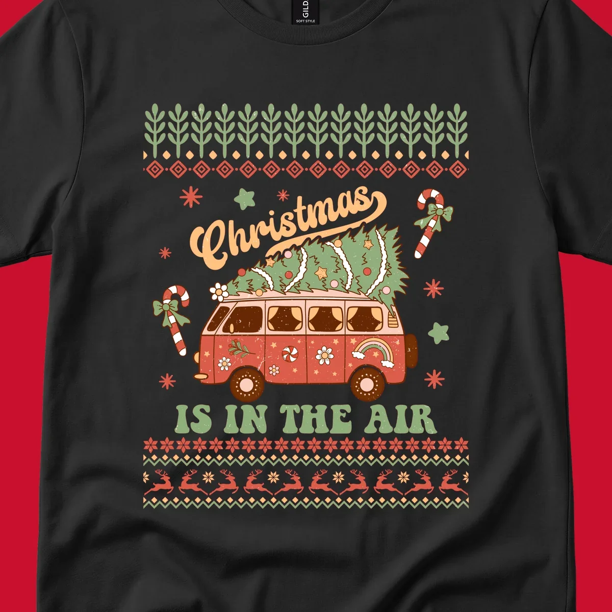 Retro Christmas van with tree on roof and 'Christmas IS IN THE AIR' text.