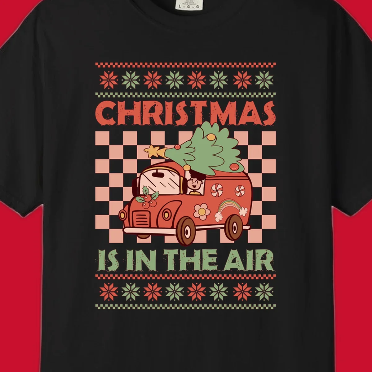 Christmas van with tree on top, text 'Christmas Is In The Air', snowflake borders, checkered pattern.