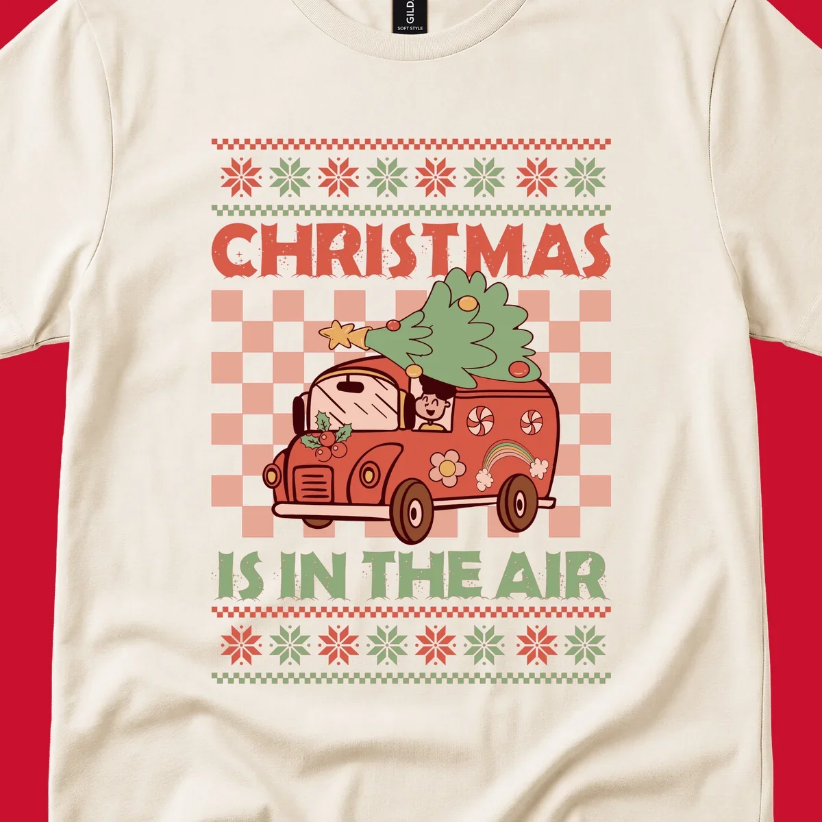 Christmas van with tree on top, text 'Christmas Is In The Air', snowflake borders, checkered pattern.