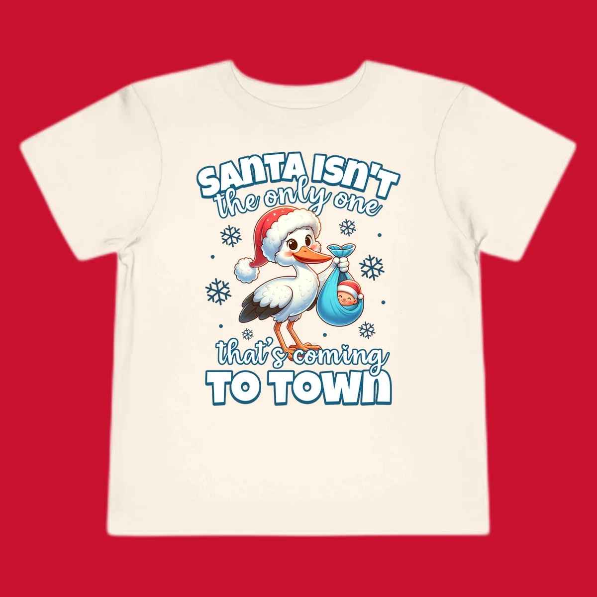 Stork carrying a baby with text "Santa Isn't The Only One That's Coming To Town".