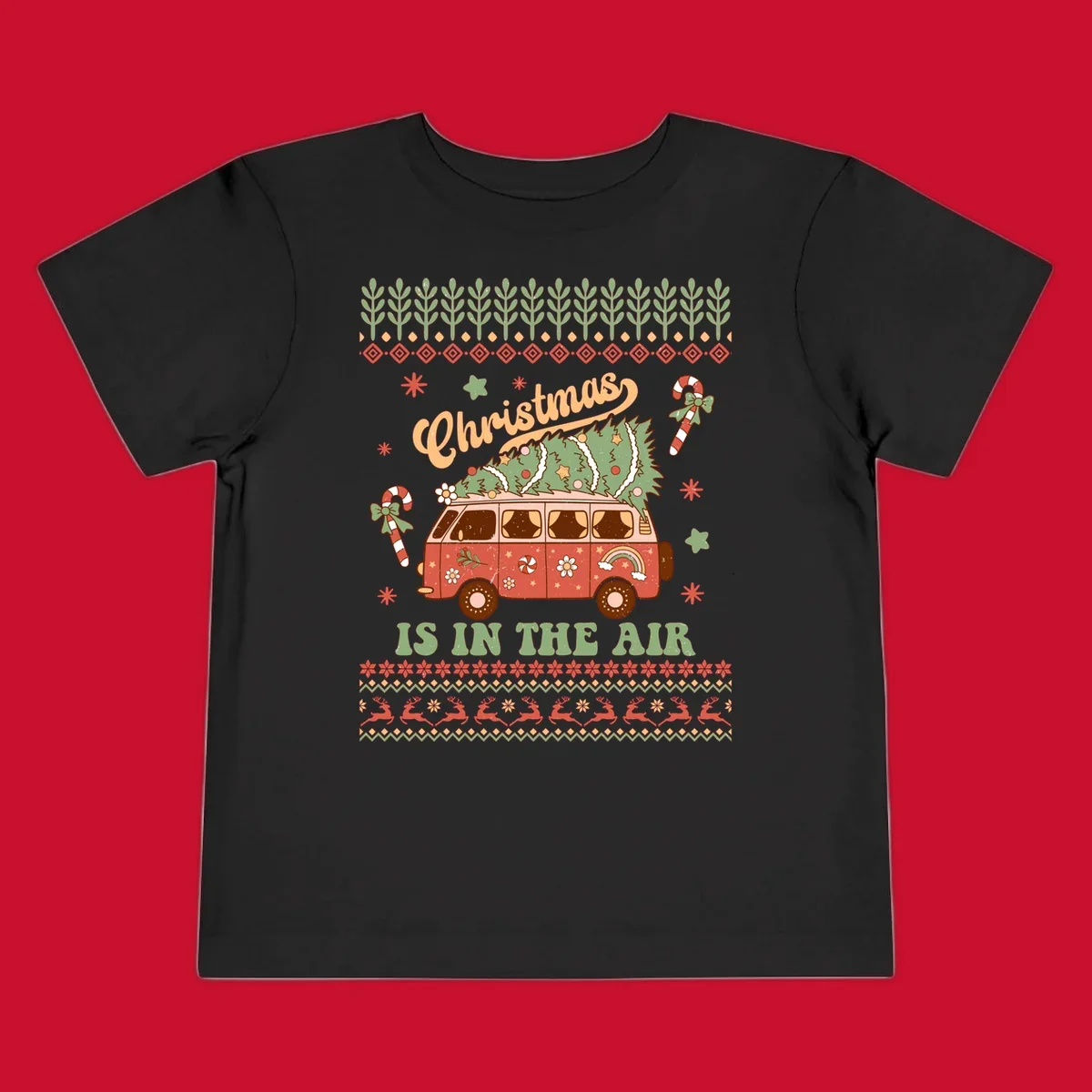 Retro Christmas van with tree on roof and 'Christmas IS IN THE AIR' text.