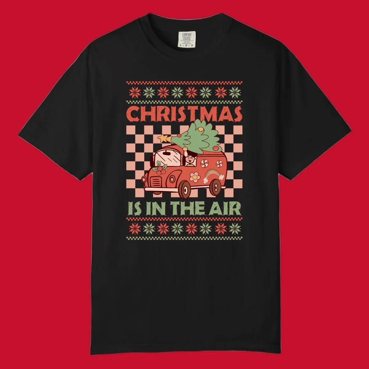 Christmas van with tree on top, text 'Christmas Is In The Air', snowflake borders, checkered pattern.