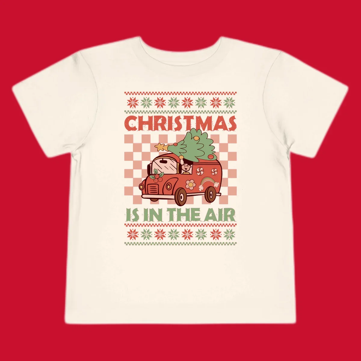 Christmas van with tree on top, text 'Christmas Is In The Air', snowflake borders, checkered pattern.